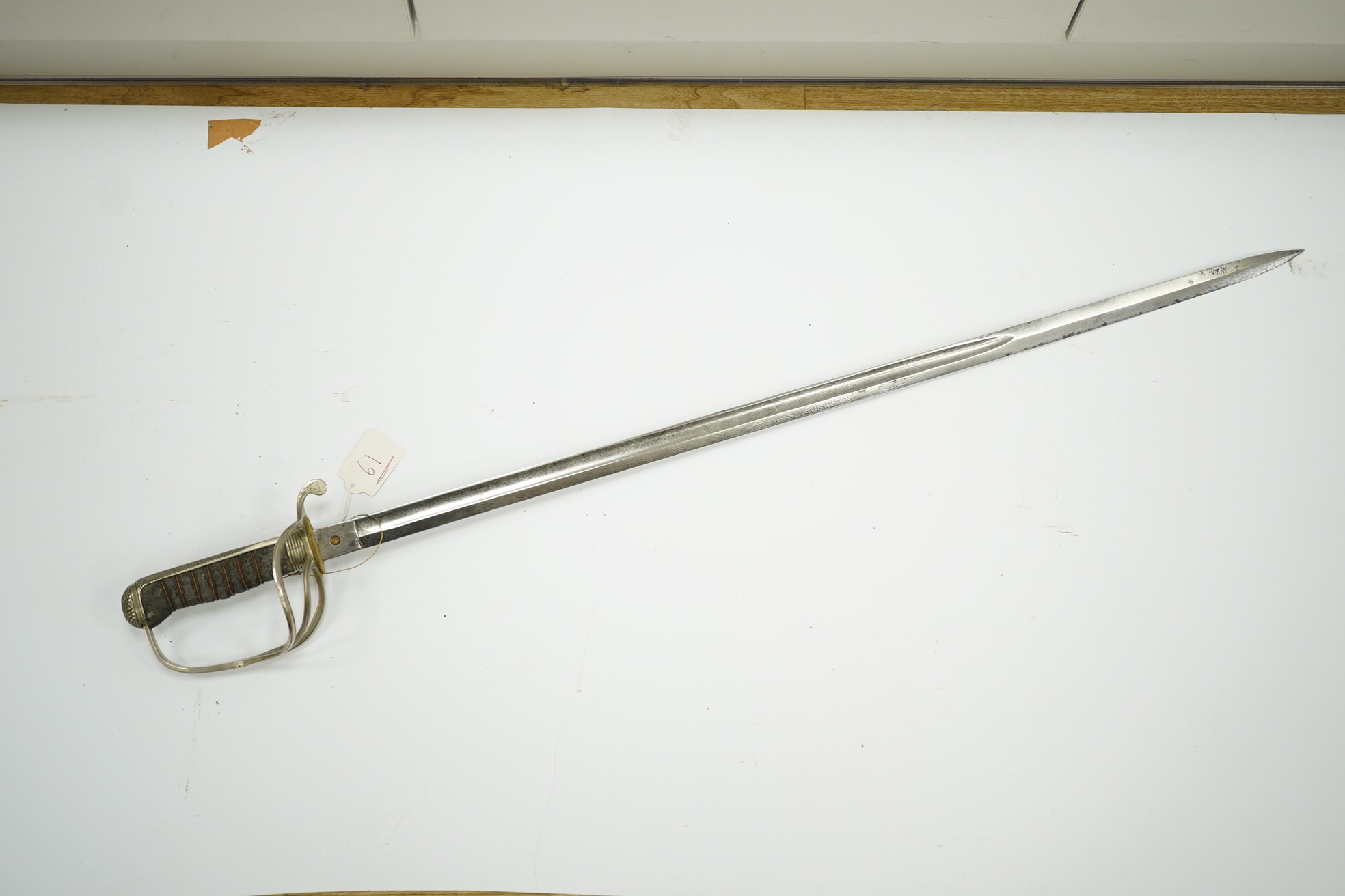 An 1821 pattern GVIR light cavalry officer’s sword in its leather scabbard, Royal Army Service Corps, blade etched with owners initials; JNDA and also with initials RASC, with regulation nickel guard, in its leather fiel